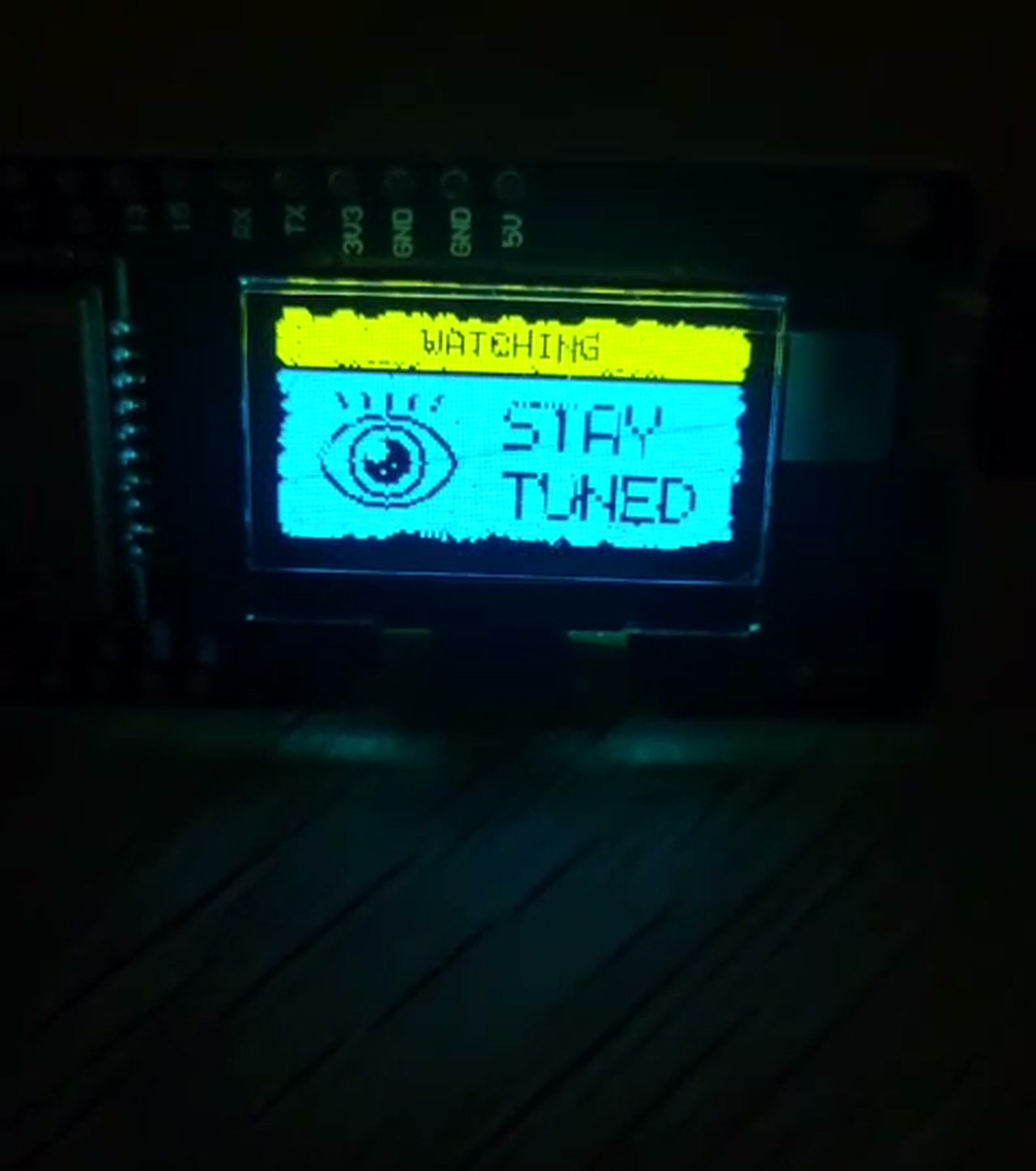 LatentField node on a workbench, OLED showing WATCHING / STAY TUNED