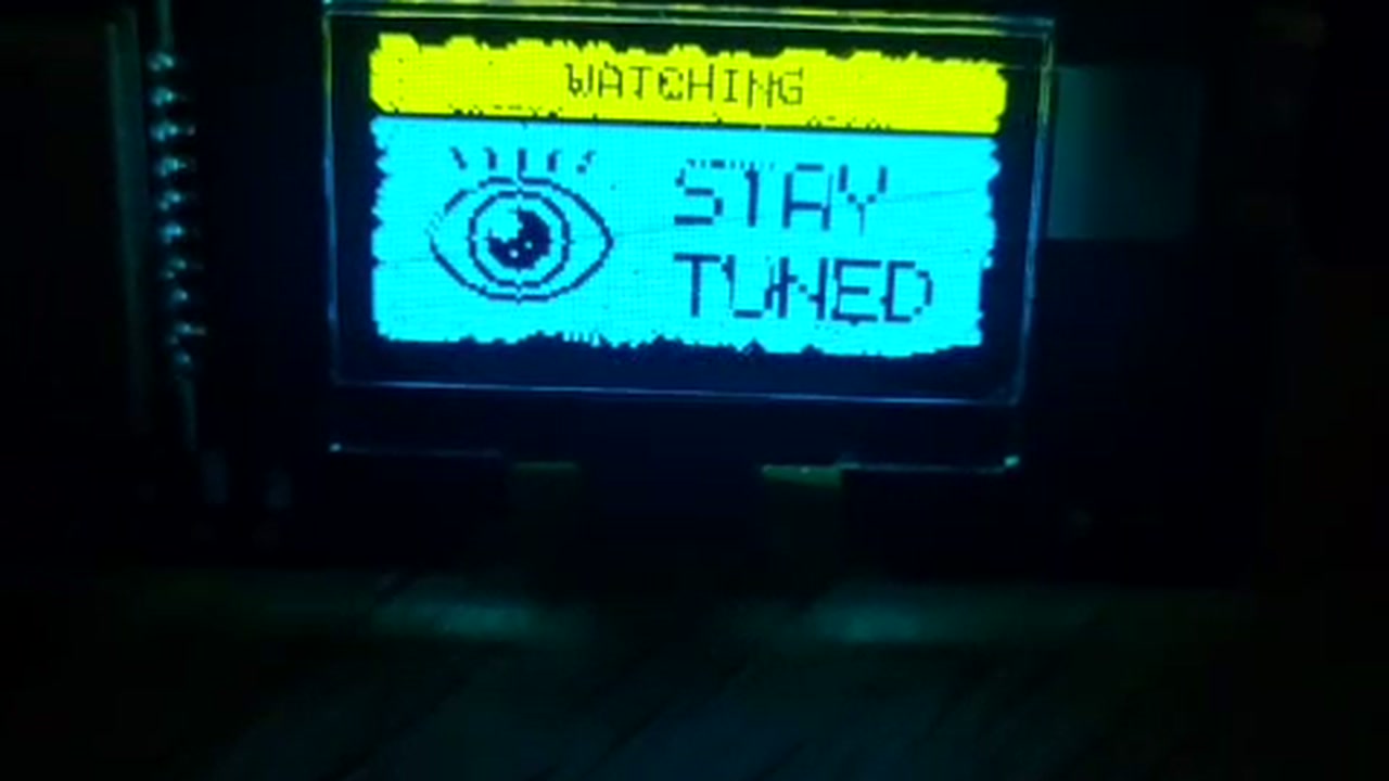 OLED frame — WATCHING / STAY TUNED — eye icon